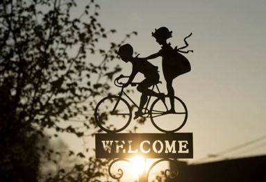 Welcome sign with boy and girl on bicycle